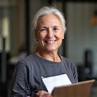 Jane Mitchell, smiling and holding a coaching clipboard